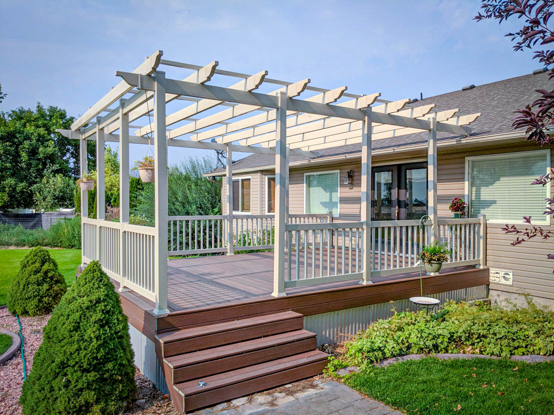 Create a seamless extension of your home with a custom patio cover from DeckPro LLC. This project in Rexburg, Idaho, showcases a tan vinyl pergola attached to a low-maintenance composite deck, offering essential shade and style. The matching railing and stair design ensure a cohesive look that withstands the local climate while providing the perfect spot for outdoor relaxation.