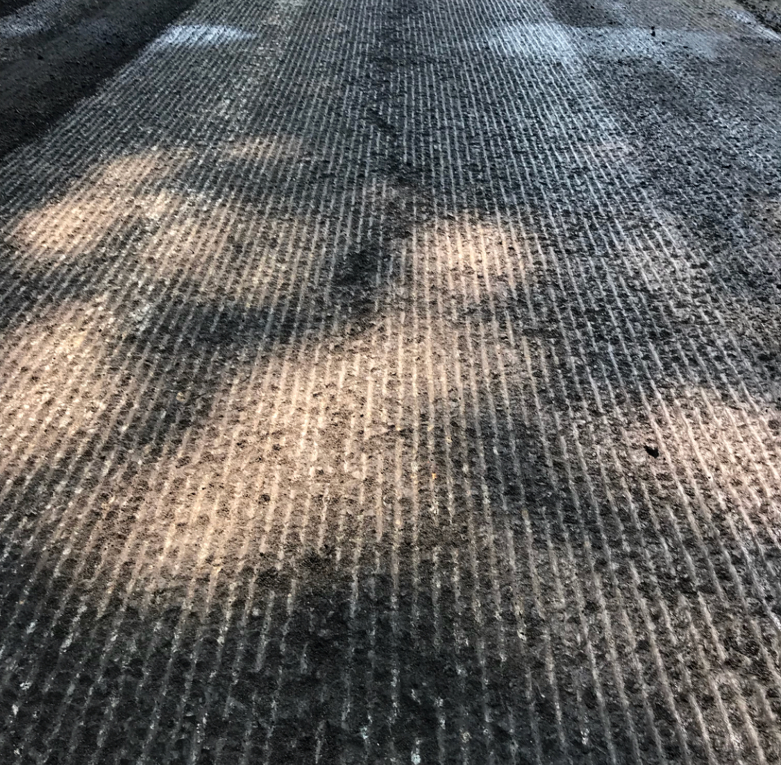 Close-up of asphalt milling, removing damaged pavement to prepare for a smooth, long-lasting new surface.