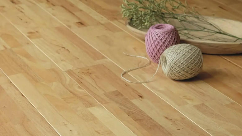 Solid wood oak flooring with two balls of string and a bowl with herbs in