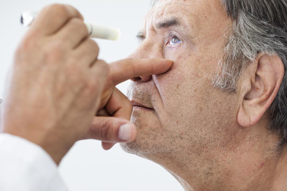 older man getting eyes checked out at eye doctor