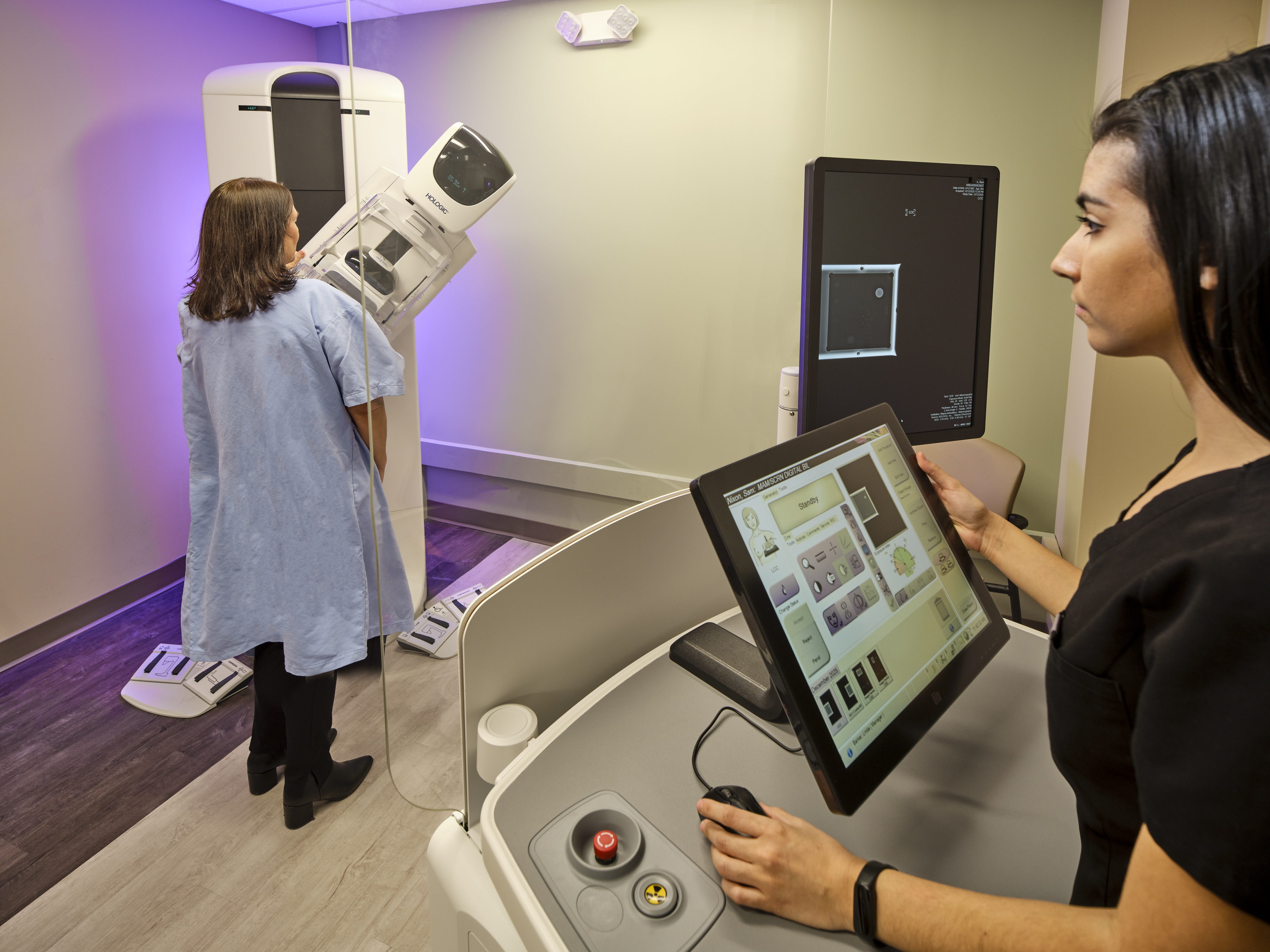 Clinician performing a mammogram.