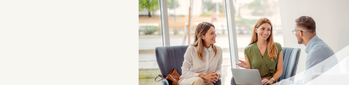 An advisor smiling during a meeting with a client couple.