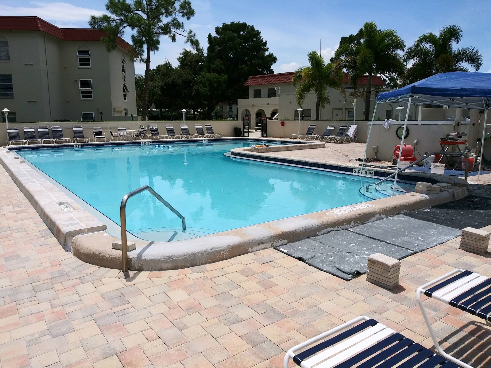 Large community swimming pool with spacious deck area, lounge seating, and resort-style amenities.