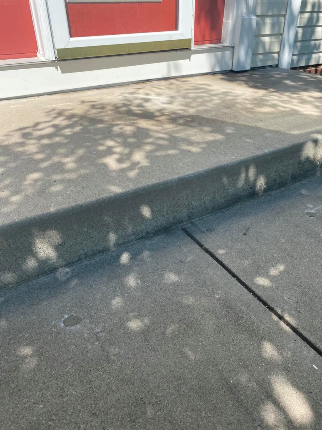 Concrete porch and entryway surface displaying smooth finishing and durable exterior craftsmanship. The residential flatwork project highlights clean concrete installation, sidewalk accessibility, outdoor surface leveling, and long-lasting structural quality for home entry and walkway areas.