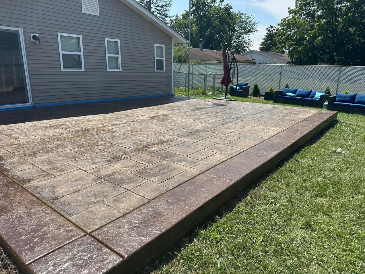 Beautiful patio with majestic Ashler slate stamp pattern. The base color is harvest wheat with a smoke release. The border is stamped with heavy stone texture and a walnut colored border