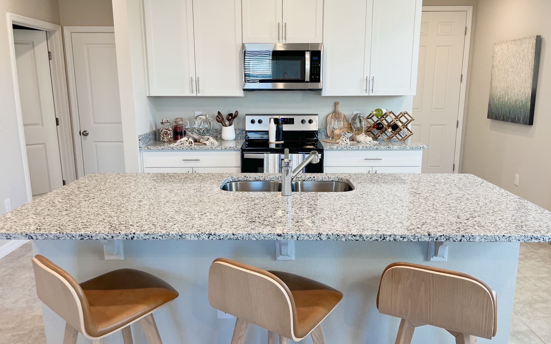 Large kitchen island with breakfast bar and stainless steel appliances.