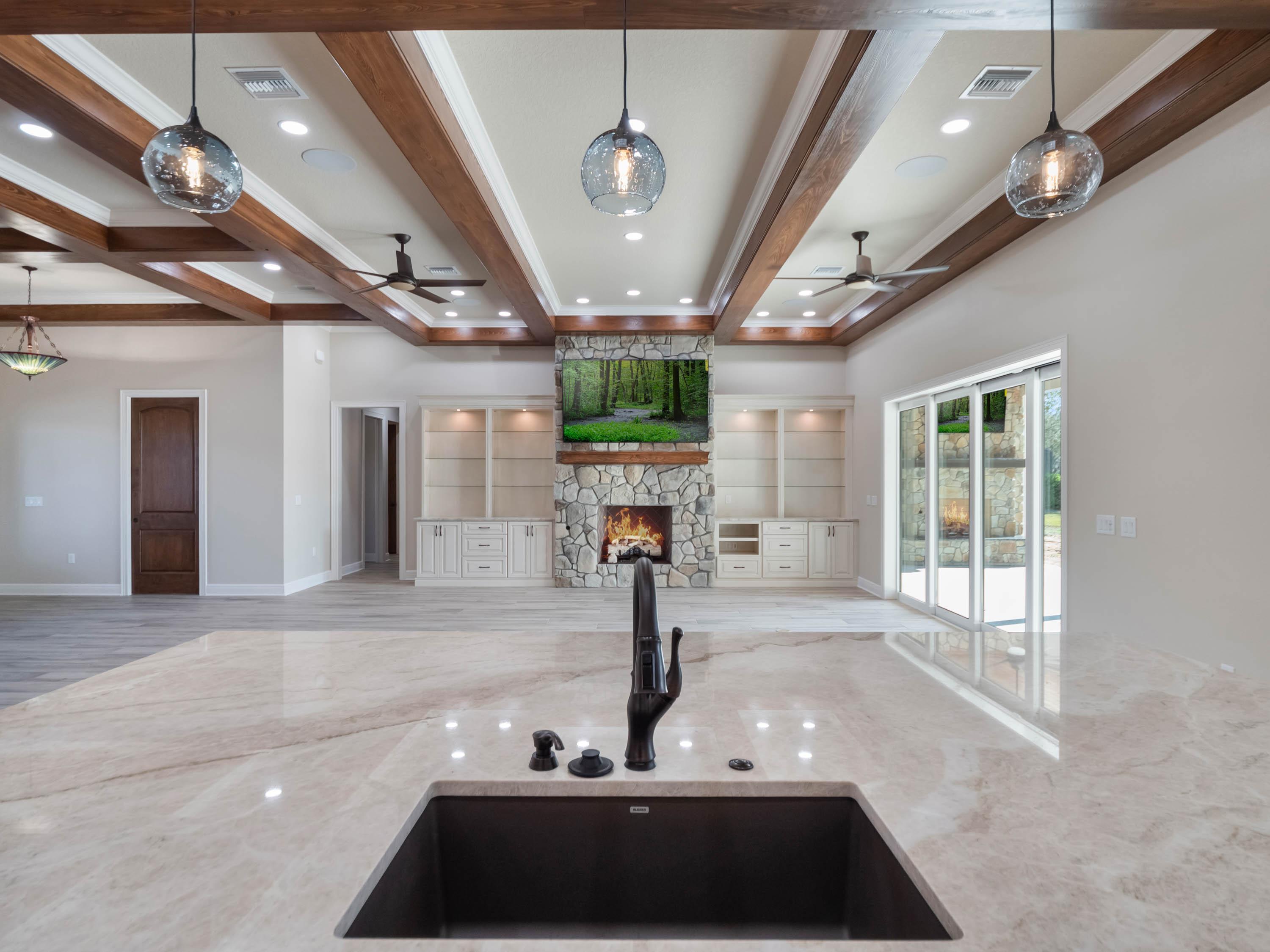 Custom-built luxury kitchen featuring a large quartz island, designer lighting, and open-concept layout by custom home builders in Central Florida.