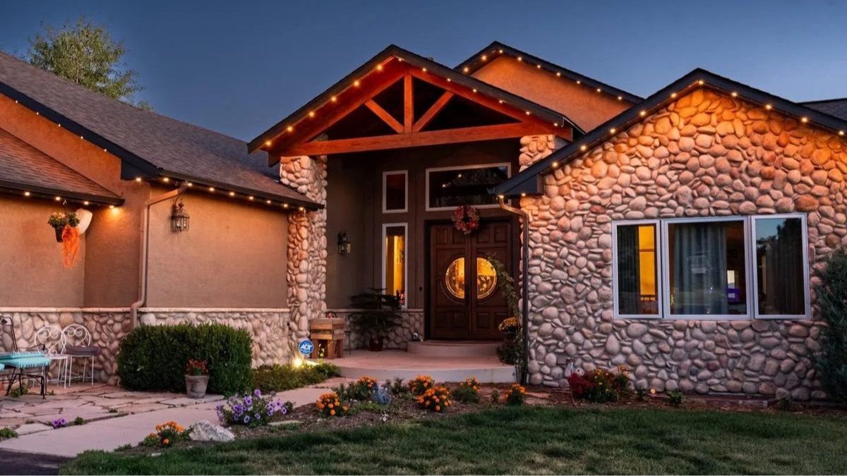 Permanent warm white roofline lighting on a Minnesota home at dusk, installed by Gray Duck Lighting.