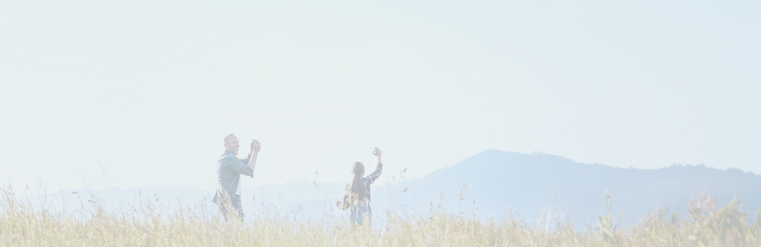 A man taking a photo of a woman in a field.