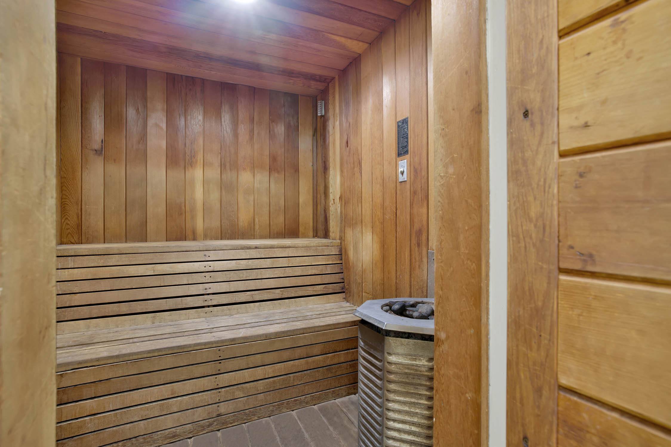 a sauna in a wooden room with a garbage can