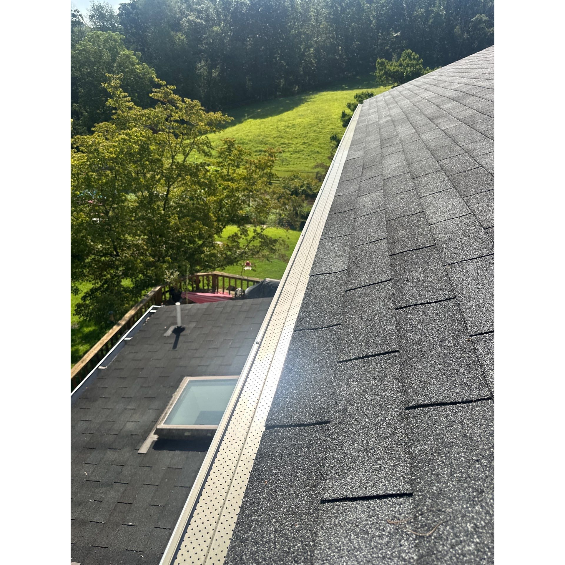Close-up of a completed micro-mesh gutter guard installation on an architectural shingle roof in Cen 