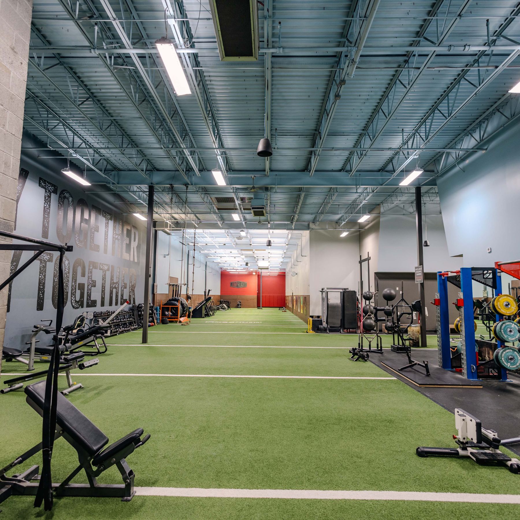 Strength training zone in our Richmond gym featuring turf flooring, racks, ropes & free weights for functional & performance-focused workouts.