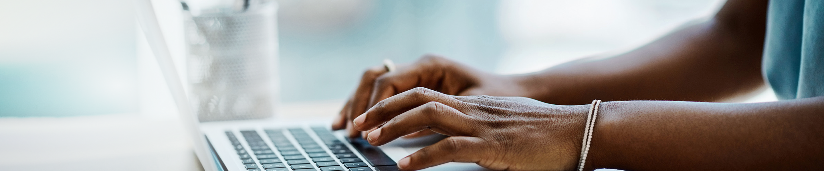 Woman's hands at laptop keyboard.