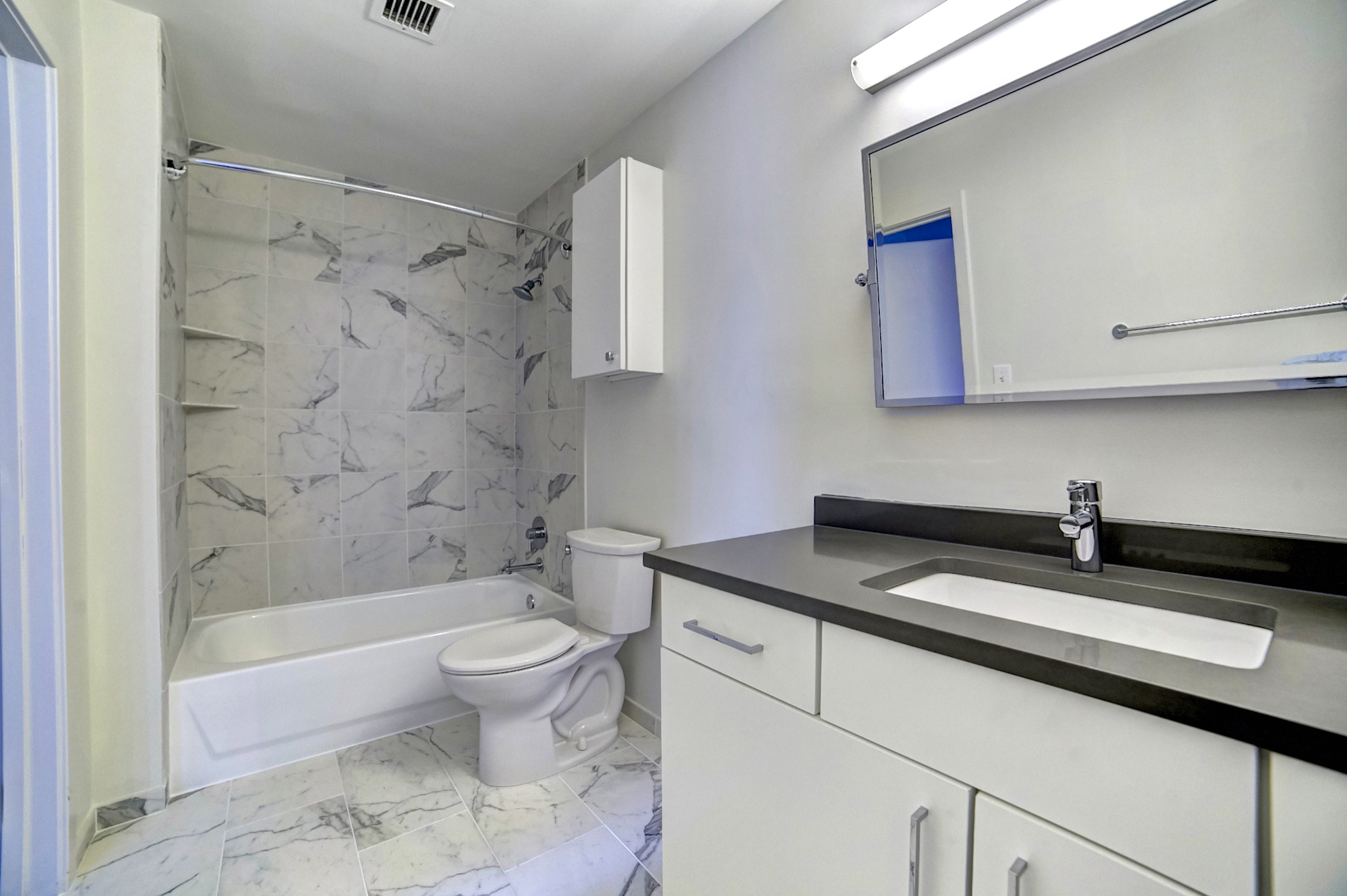 white Bathroom with a bathtub a toilet and a sink 