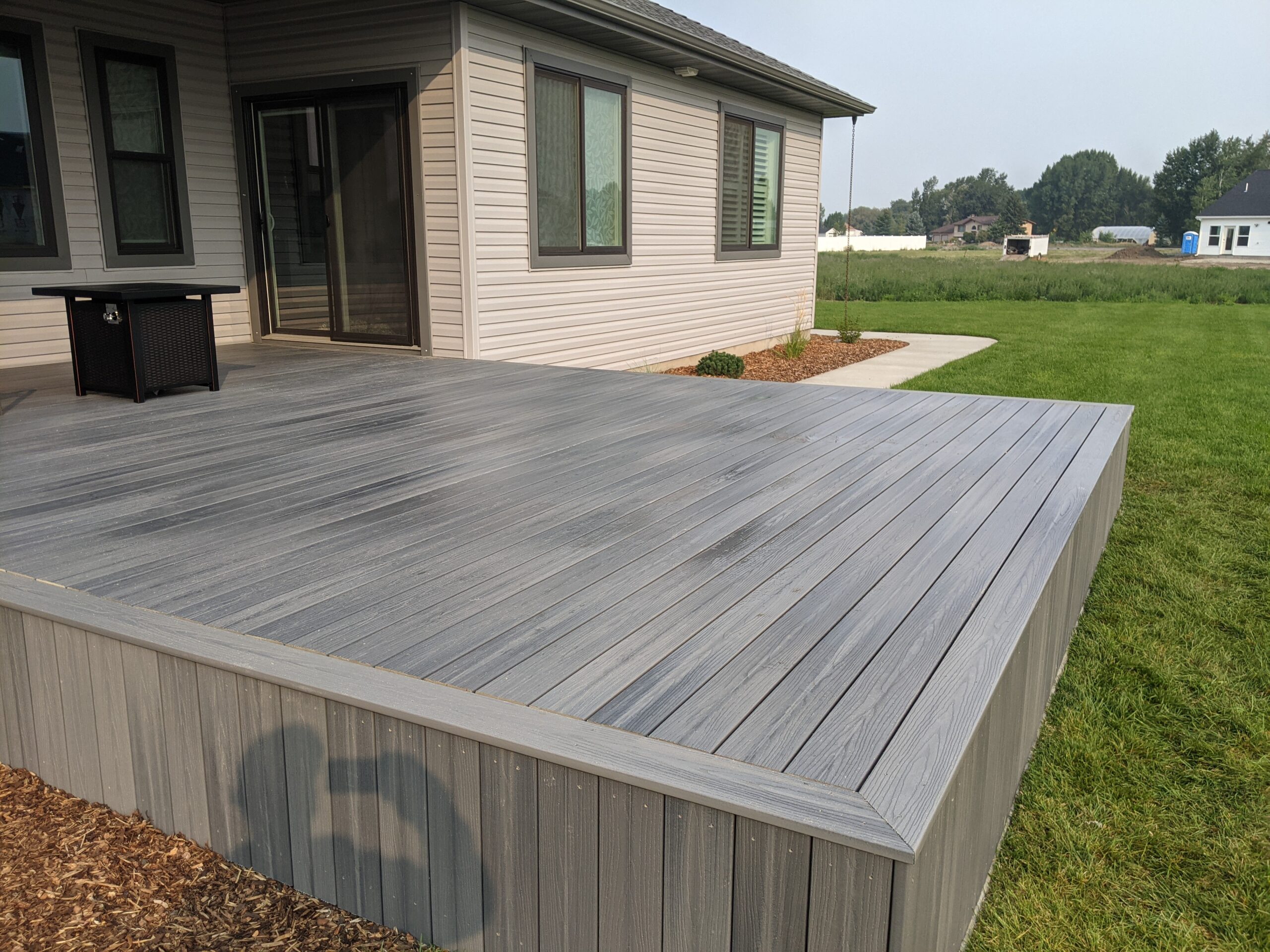 Expand your outdoor living space with this custom deck project by DeckPro LLC, designed to blend rustic charm with modern durability. This build features low-maintenance composite decking and a unique perimeter railing that combines natural wood posts with wire mesh infill panels. The functional design includes extensive built-in bench seating, making it an inviting retreat perfect for relaxing and taking in scenic, natural views.