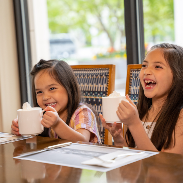 Two children smiling and enjoying hot chocolate at the Little America Hotel. The Little America Hotel - Salt Lake City Salt Lake City (801)596-5700