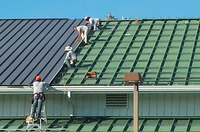 Roofers at work doing metal roofing duties at Minneapolis, MN