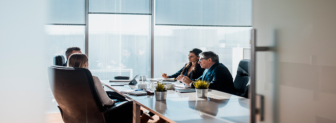 Professionals collaborating around a boardroom table.