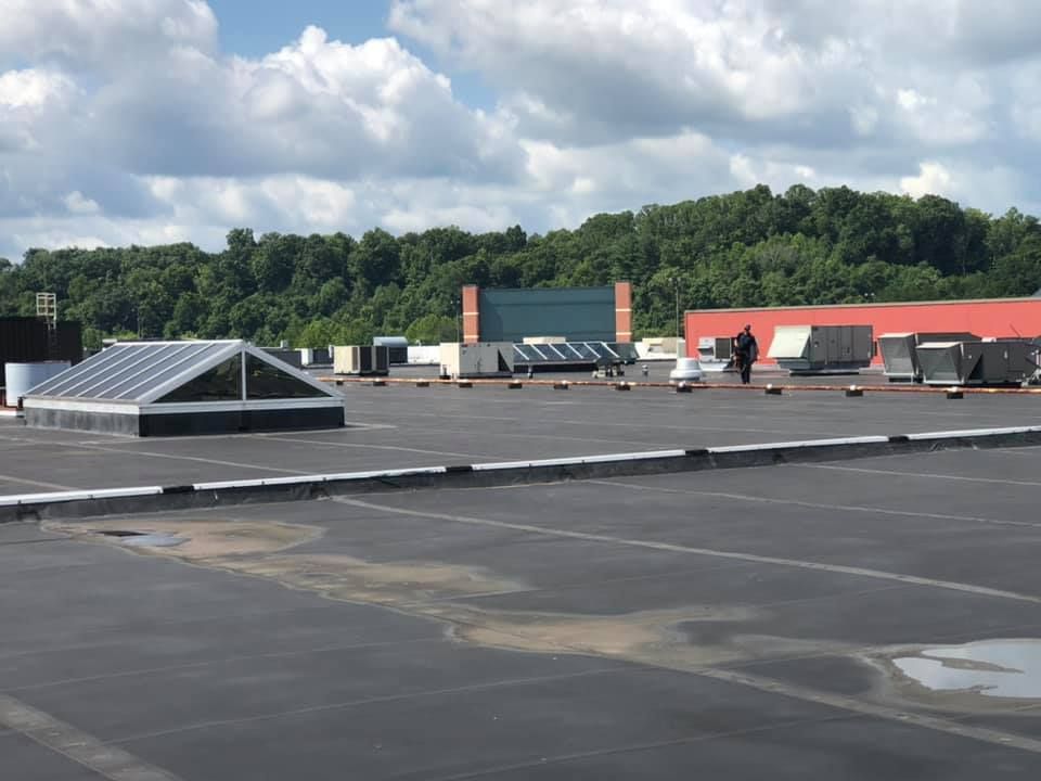 Partially obscured image with blurred text overlays covering most of frame, faintly showing rooftop surface and possible outdoor area beneath, making scene unclear and preventing identification of specific objects or activities.