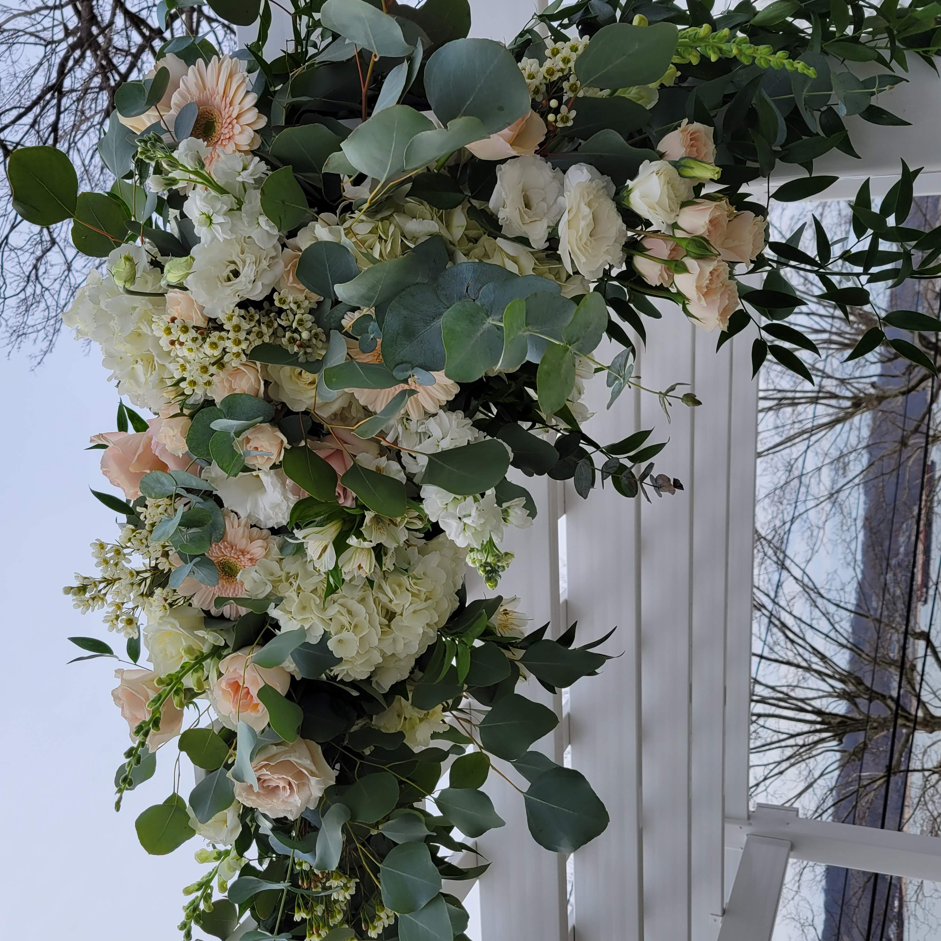 March wedding ceremony arch with spring flowers in a neutral color palette at Seacliff Manor, Seacliff NY. Roses, hydrangea, gerbera daisies, garden roses, spray roses, lisianthus, and eucalyptus.