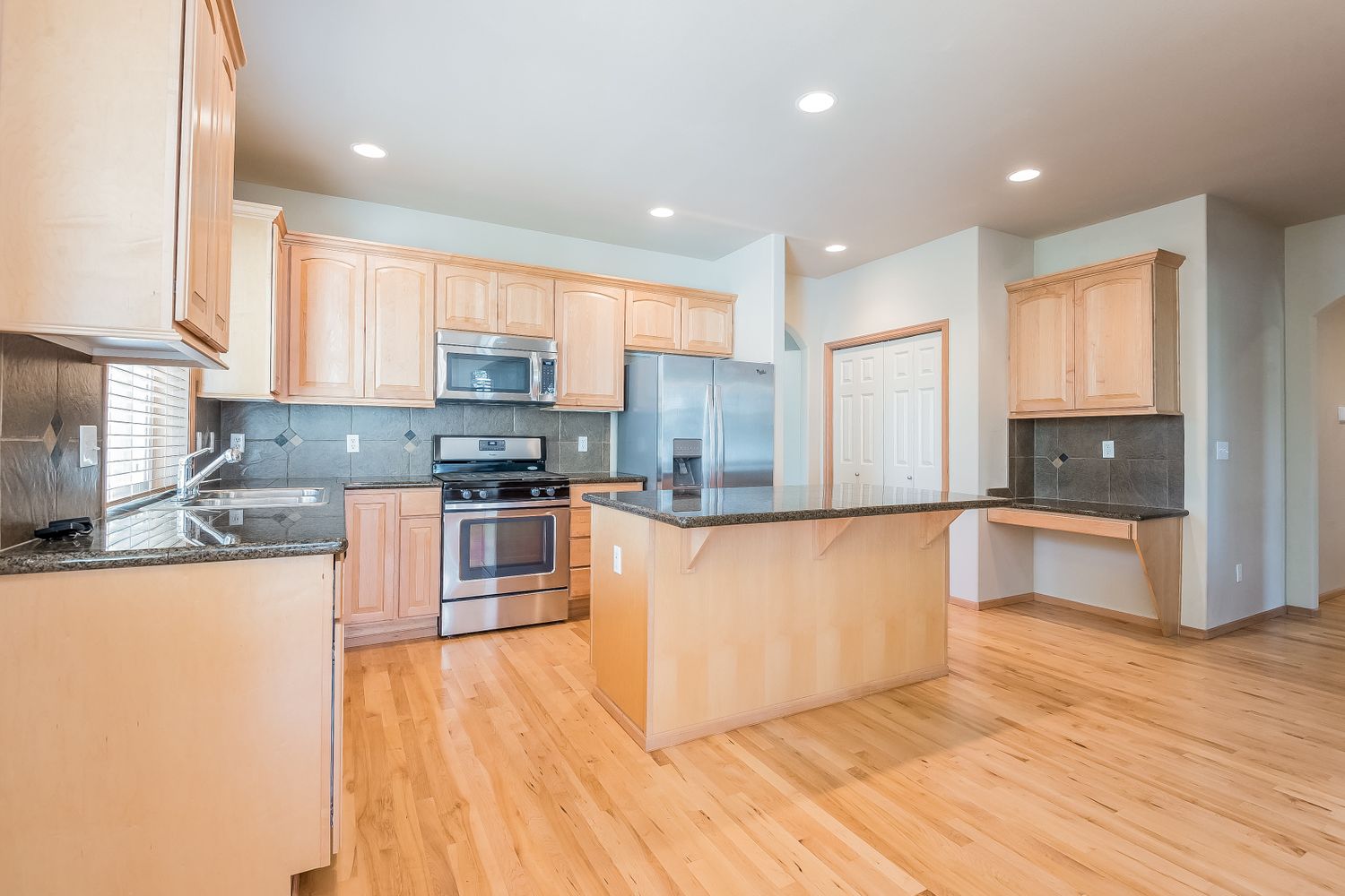 Bright kitchen with recessed lighting and stainless-steel appliances at Invitation Homes Seattle.