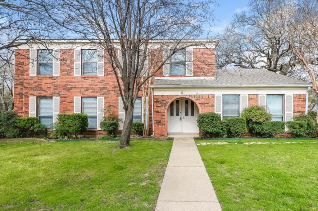 Front of home with double doors and arched, covered patio entrance at Invitation Homes Dallas.