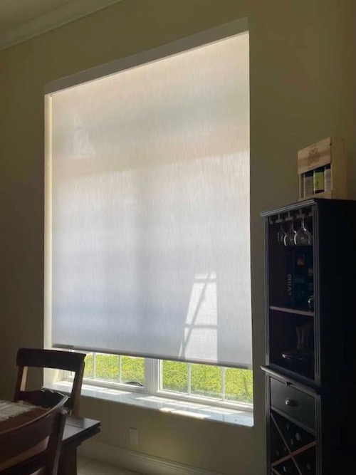 These locally installed roller shades brighten this dining room beautifully. Roller shades provide customizable light control, UV protection with style, an extensive fabric selection, and so much more!