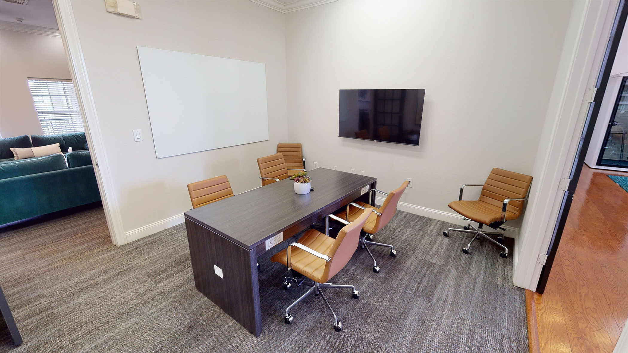 A conference room with a 4 person table and TV with HDMI hookup