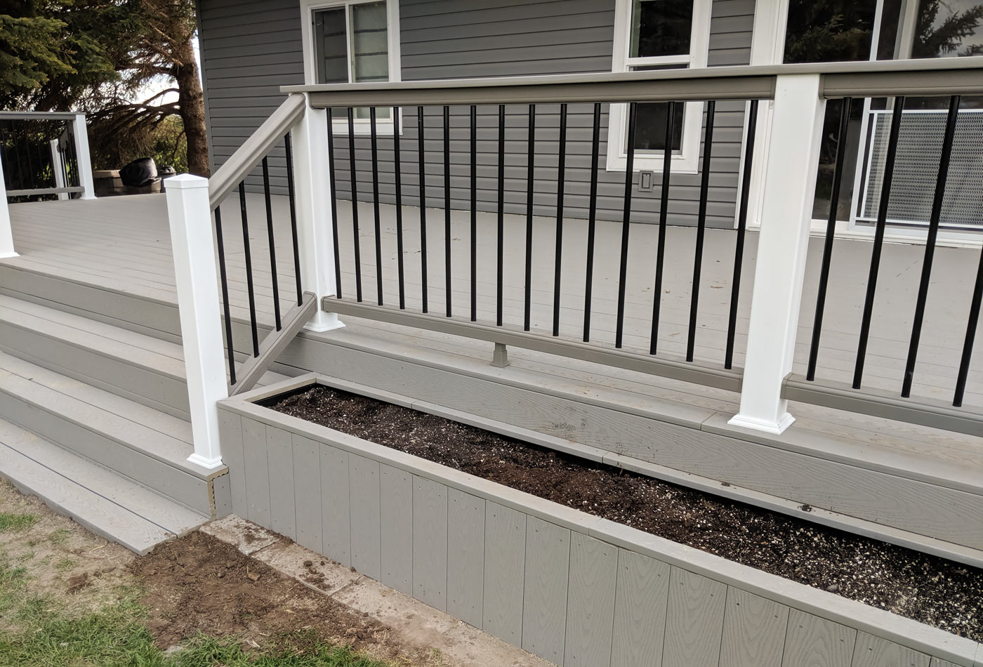 Add a touch of nature directly to your deck design with a custom built-in planter from DeckPro LLC. This project features low-maintenance grey composite decking and an integrated planter box, ready for your favorite flowers or herbs.