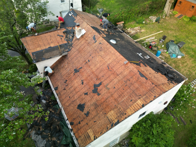 Roofing contractors perform a complete tear-off of aging shingles before replacement. Removing damag 