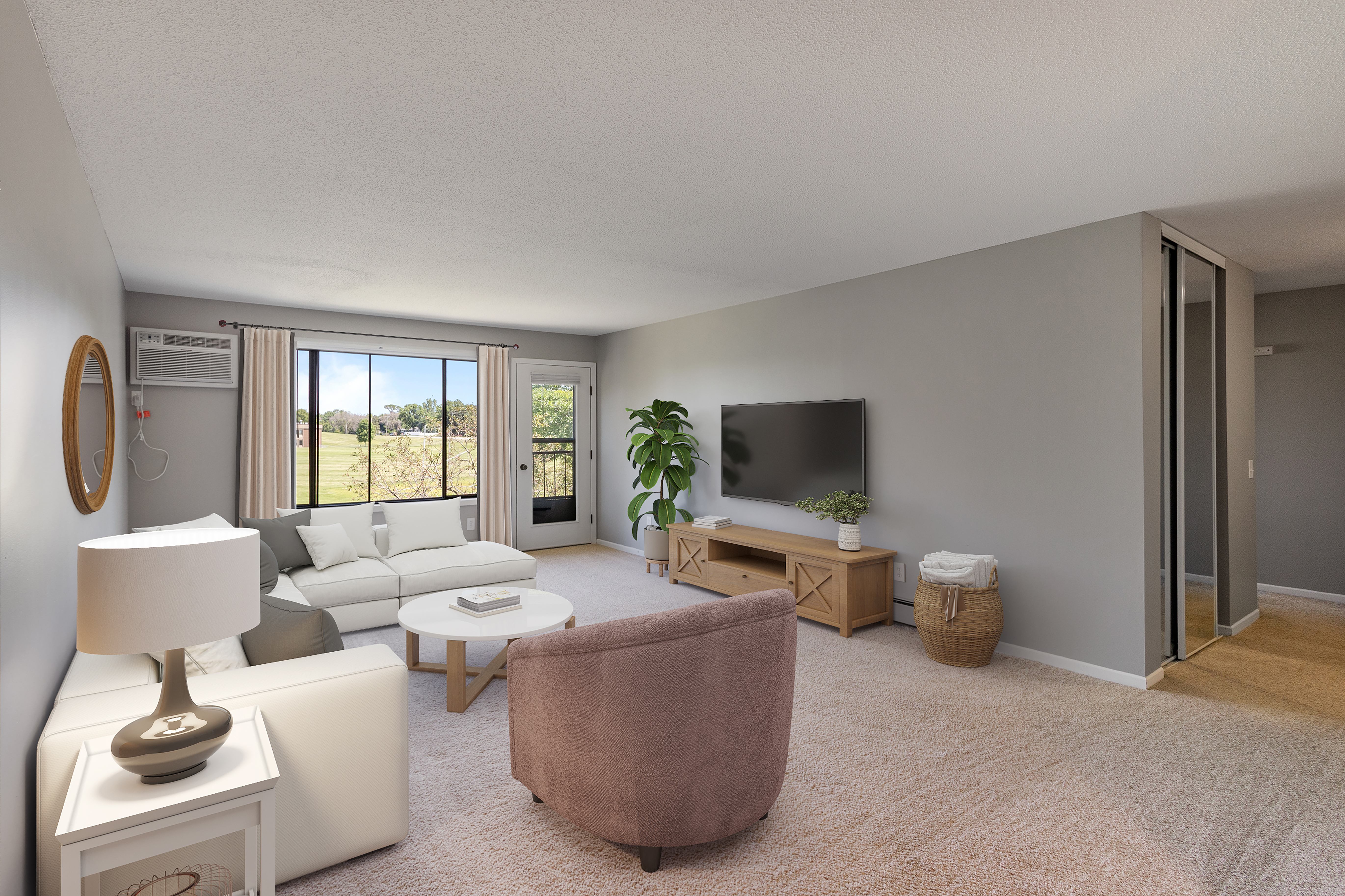 A living room with a brown chair, a white sofa and a sliding glass door leading to a balcony