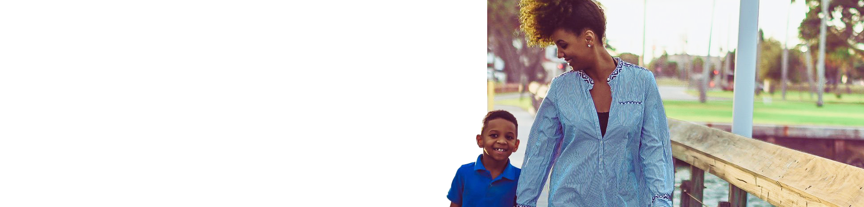 Mom and son walking hand in hand on a pier.