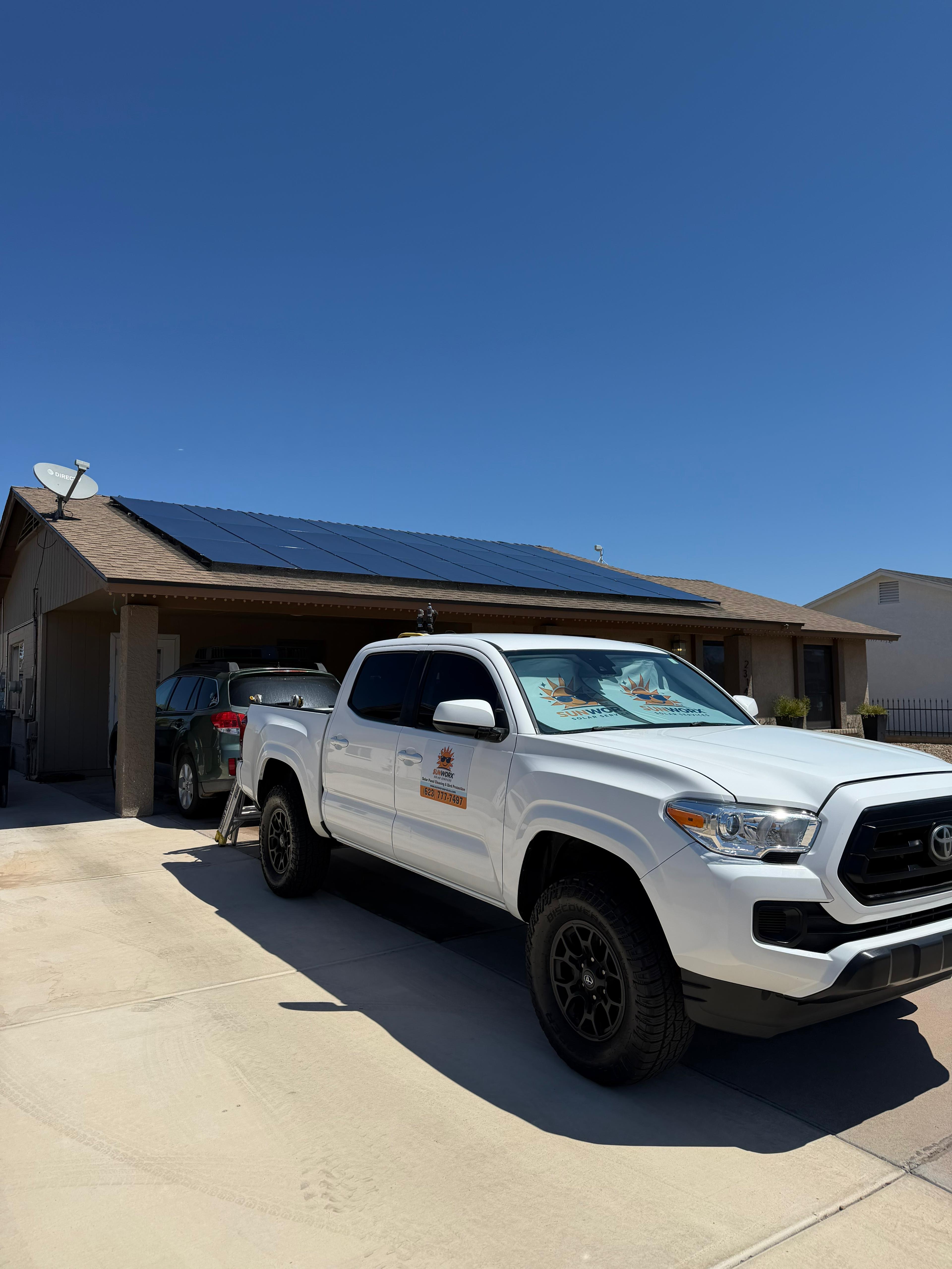 SunWorx Solar Services truck at an Arizona residential solar project with a large rooftop photovoltaic array visible on the home.