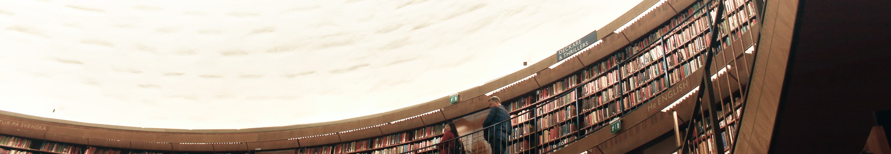 A beautiful curved library with a well-lit ceiling.