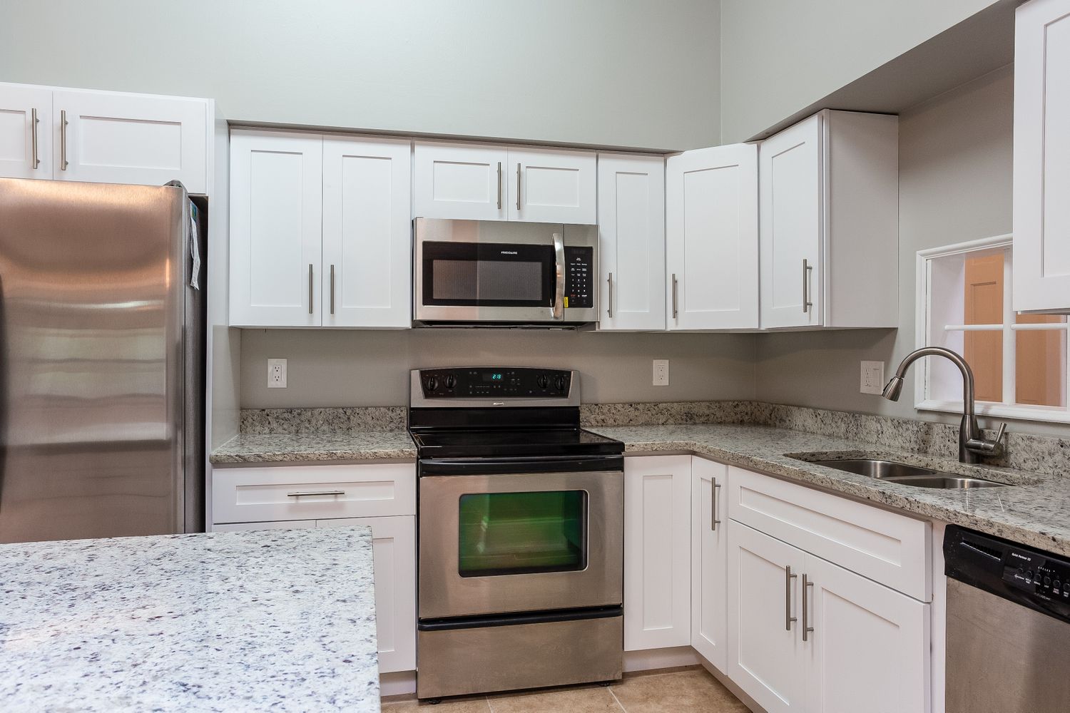 Gorgeous kitchen with granite and stainless steel appliances at Invitation Homes South Florida.