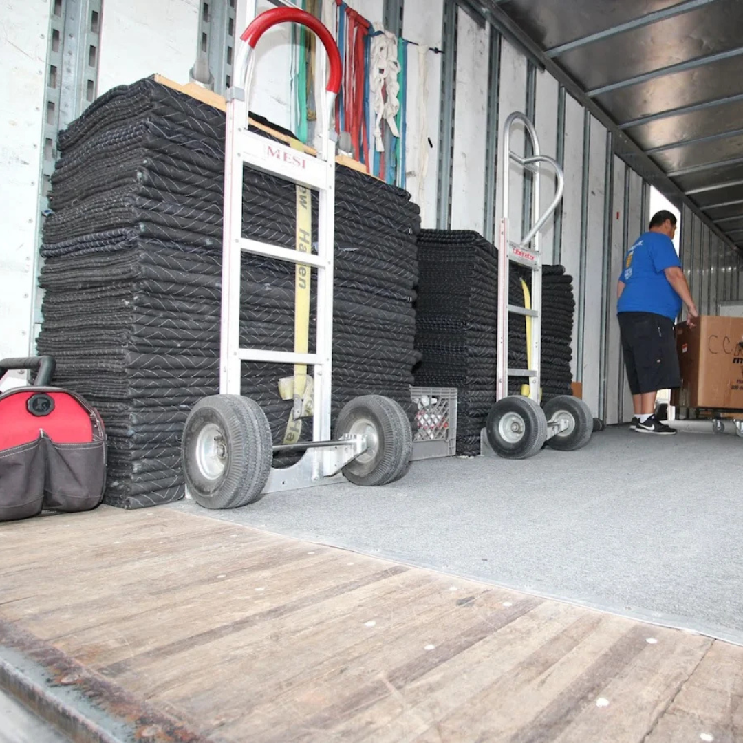 Moving blankets, dollies, and equipment loaded into an Econo Move & Storage truck for professional r 