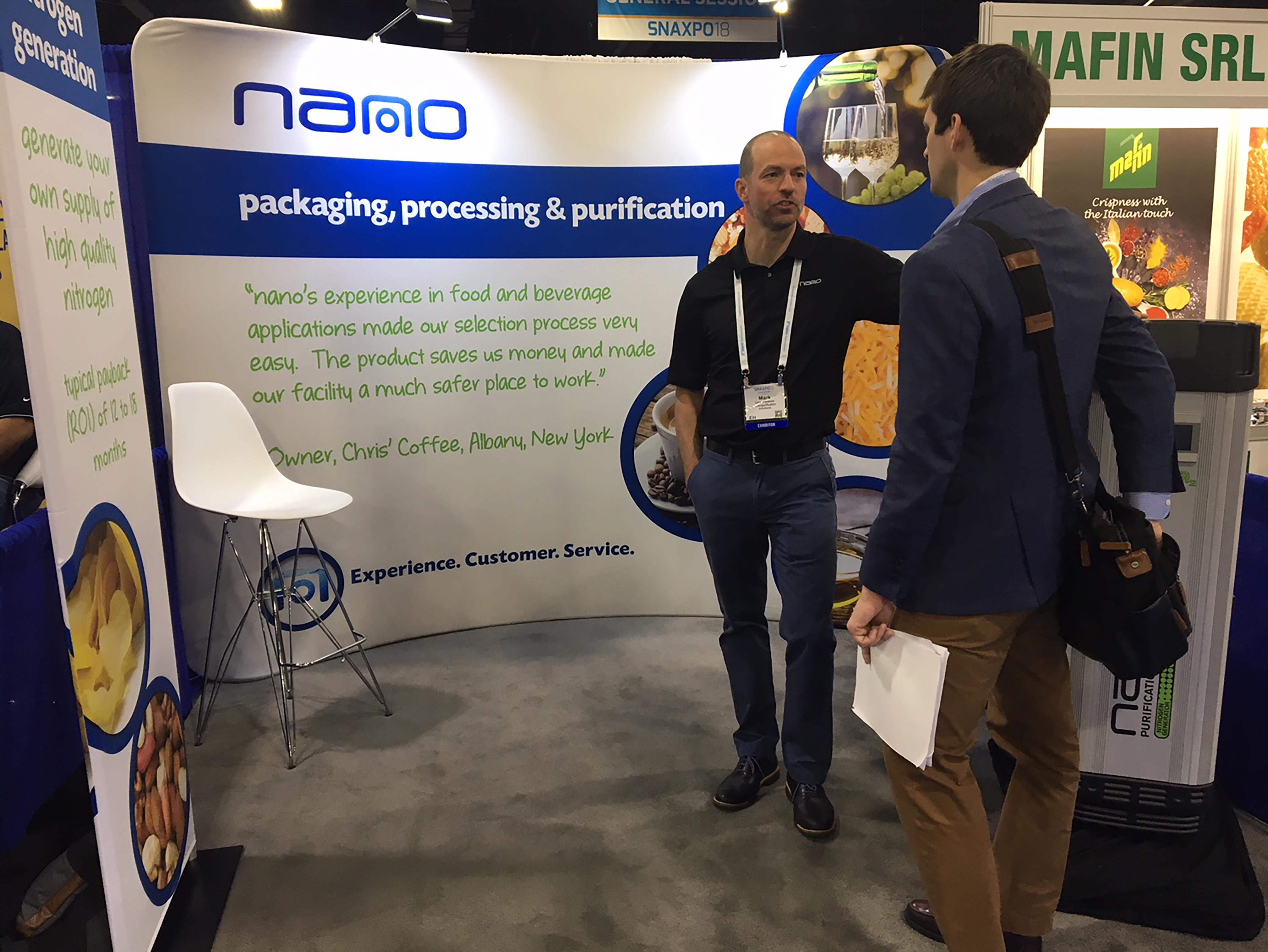 nano employee speaking to a customer, who is interested in a nano nitrogen generator, at a snack food industry tradeshow
