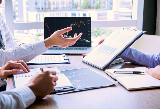 A group of people with notebooks at an office table.