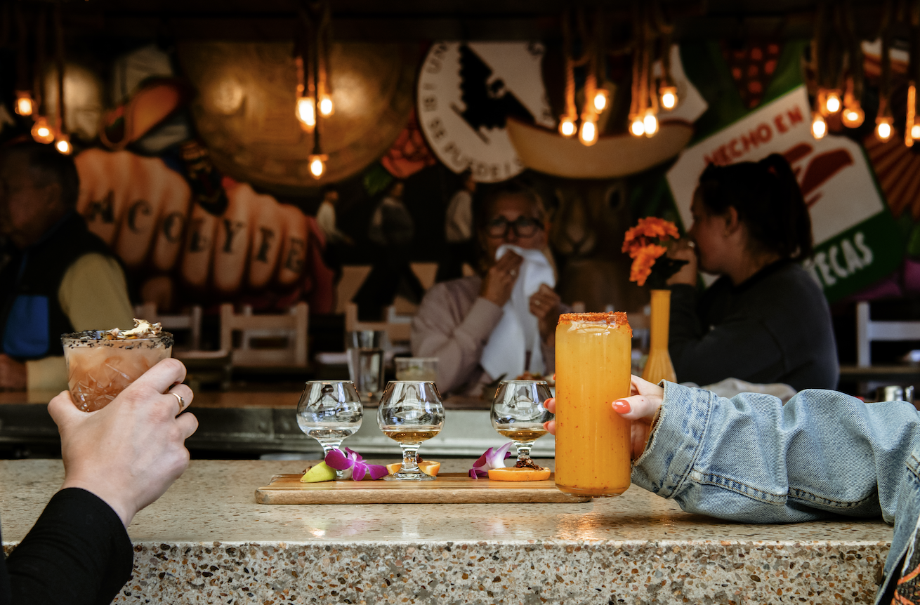 People sitting at the bar drinking craft cocktails