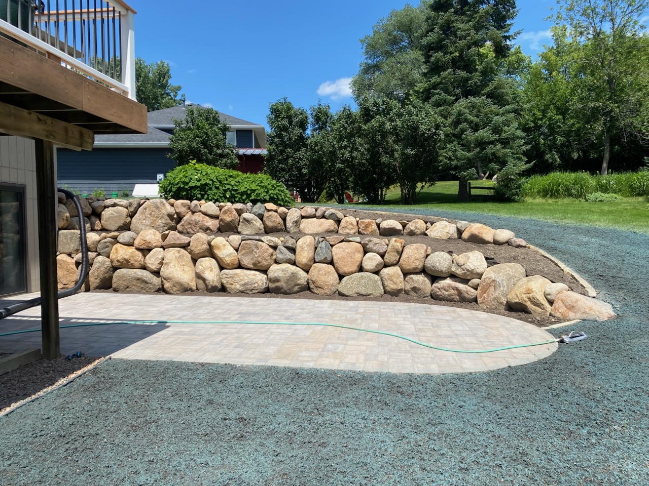 Beautiful natural boulders paired with a classic paver patio, functional, durable, and designed to enhance your outdoor living space.