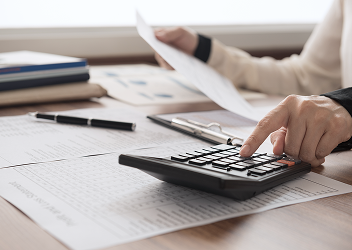 Close-up of a professional typing on a calculator.