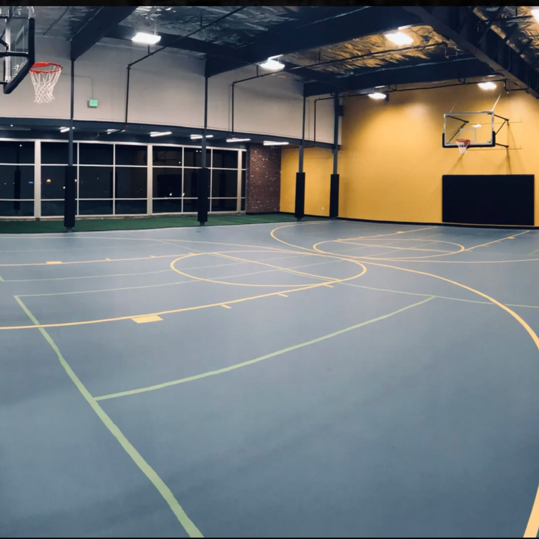The basketball court at our Cheyenne gym features multiple hoops, a spacious playing surface, and high ceilings for pickup games, drills, and individual practice. Large windows bring natural light into the court, creating an inviting space for members to stay active beyond the weight room.