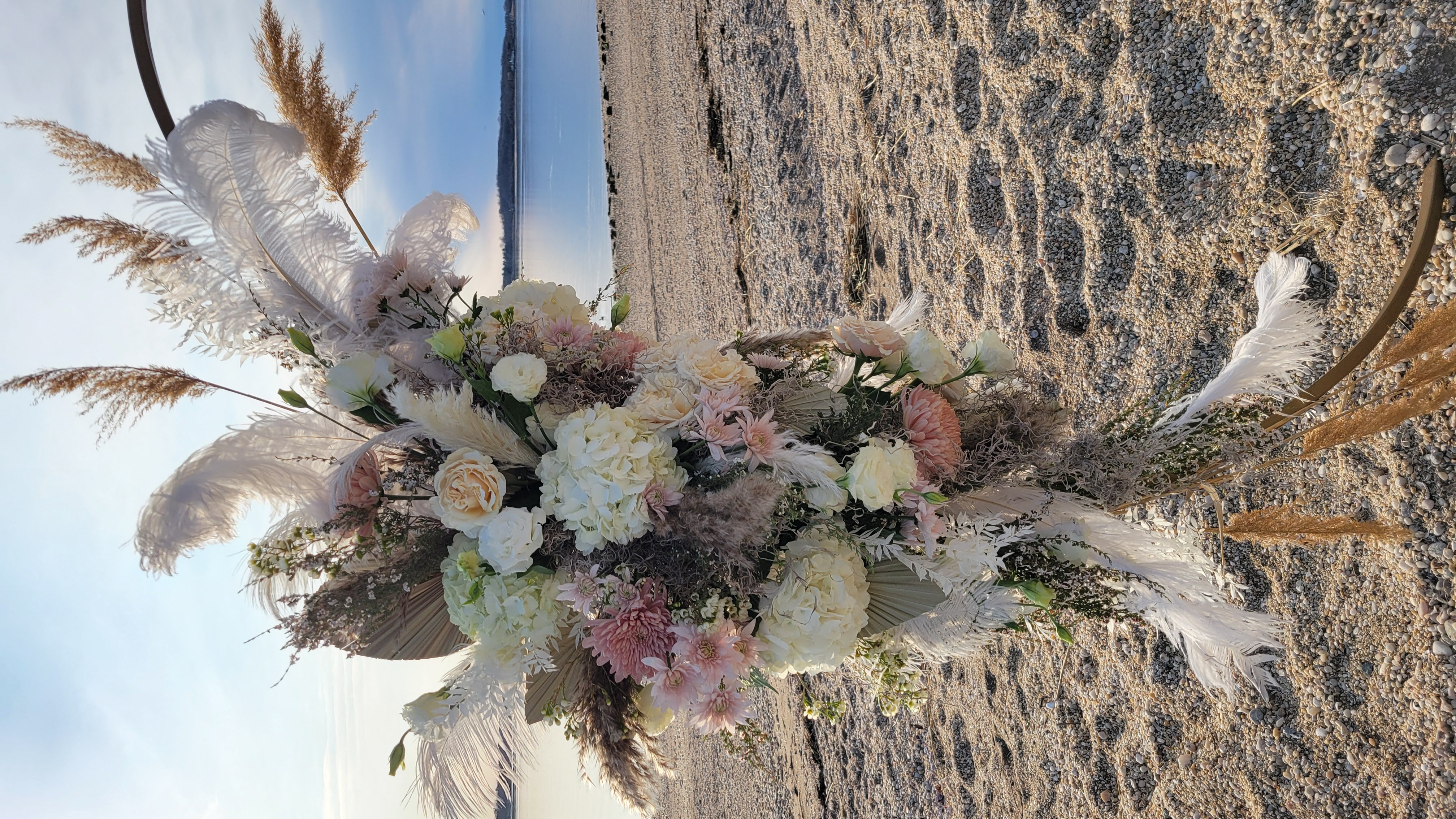 Boho wedding ceremony circle arch. West Neck Beach, Huntington NY. Neutral color palette with pampas grass, and ostrich feathers
