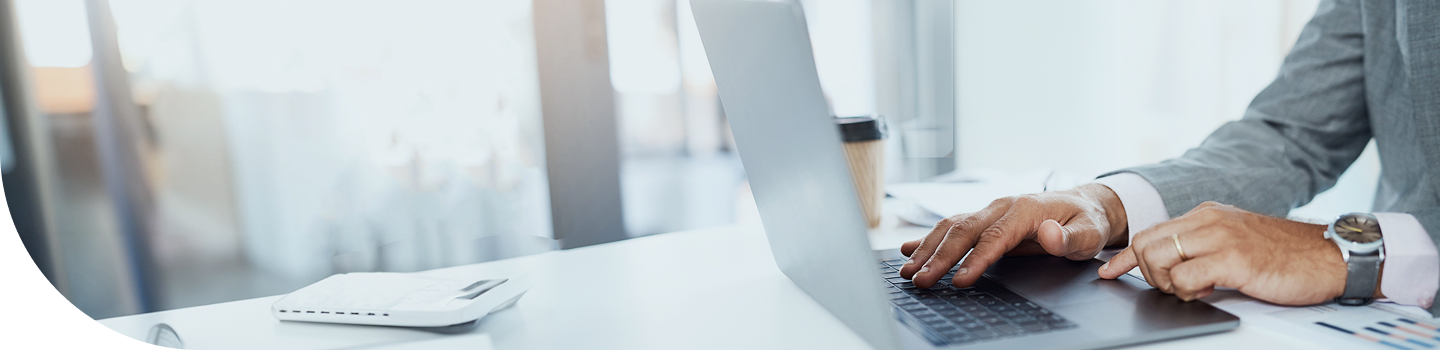 A close-up shot of a person at their laptop.