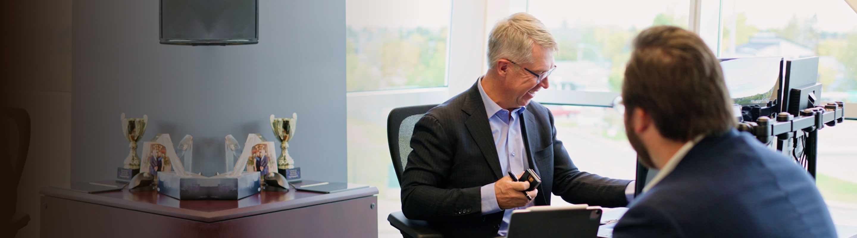 Kevin Chrenek and Tyson Beaupre in discussion in an office.
