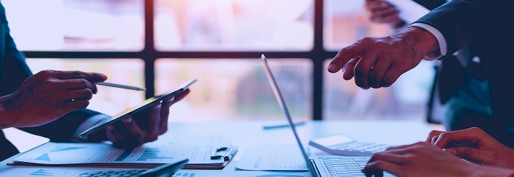 Close up of two people working at a desk.