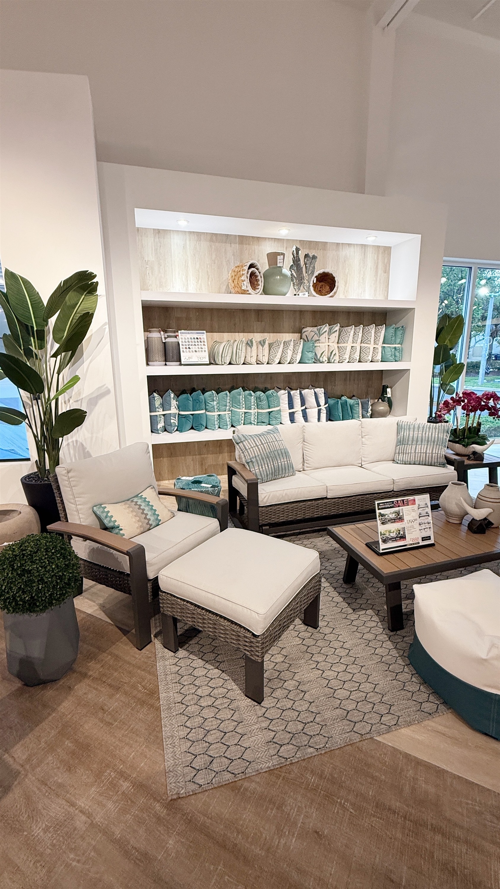 Create the perfect outdoor retreat with this wicker conversation set in cream cushions and teal accents.