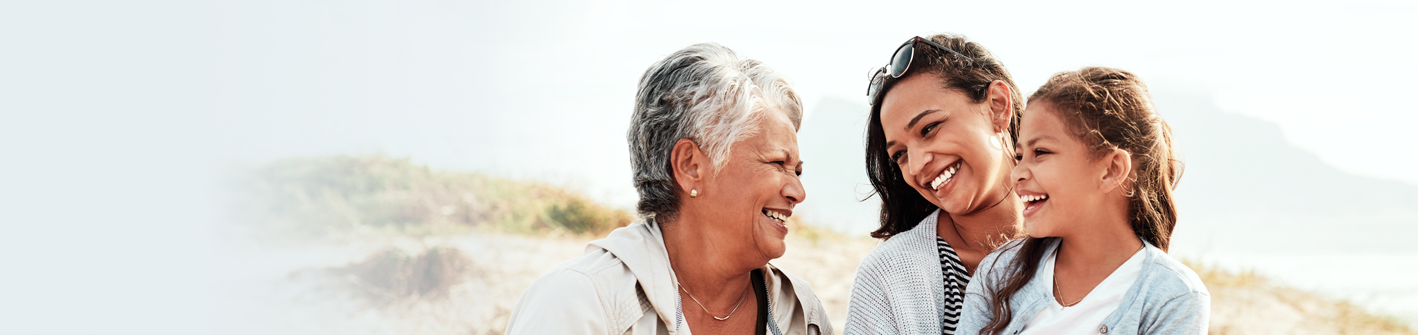 A grandmother with laughing with her daughter and granddaughter.