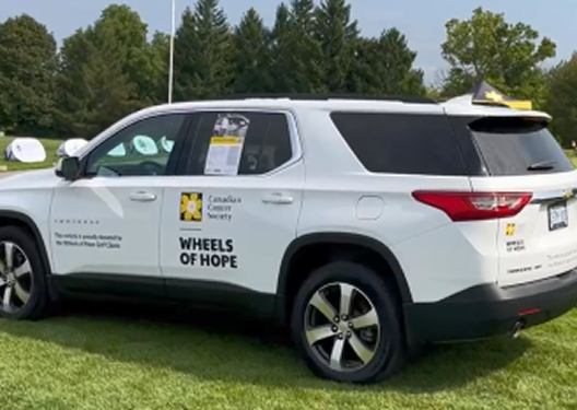 Photo of an SUV with the Wheels of Hope Golf Classic logo on the side.