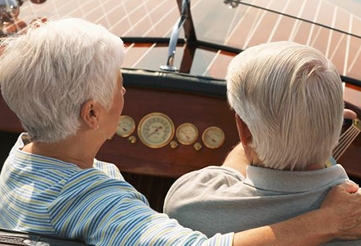 Over-the-shoulder shot of an elderly couple on a private boat.